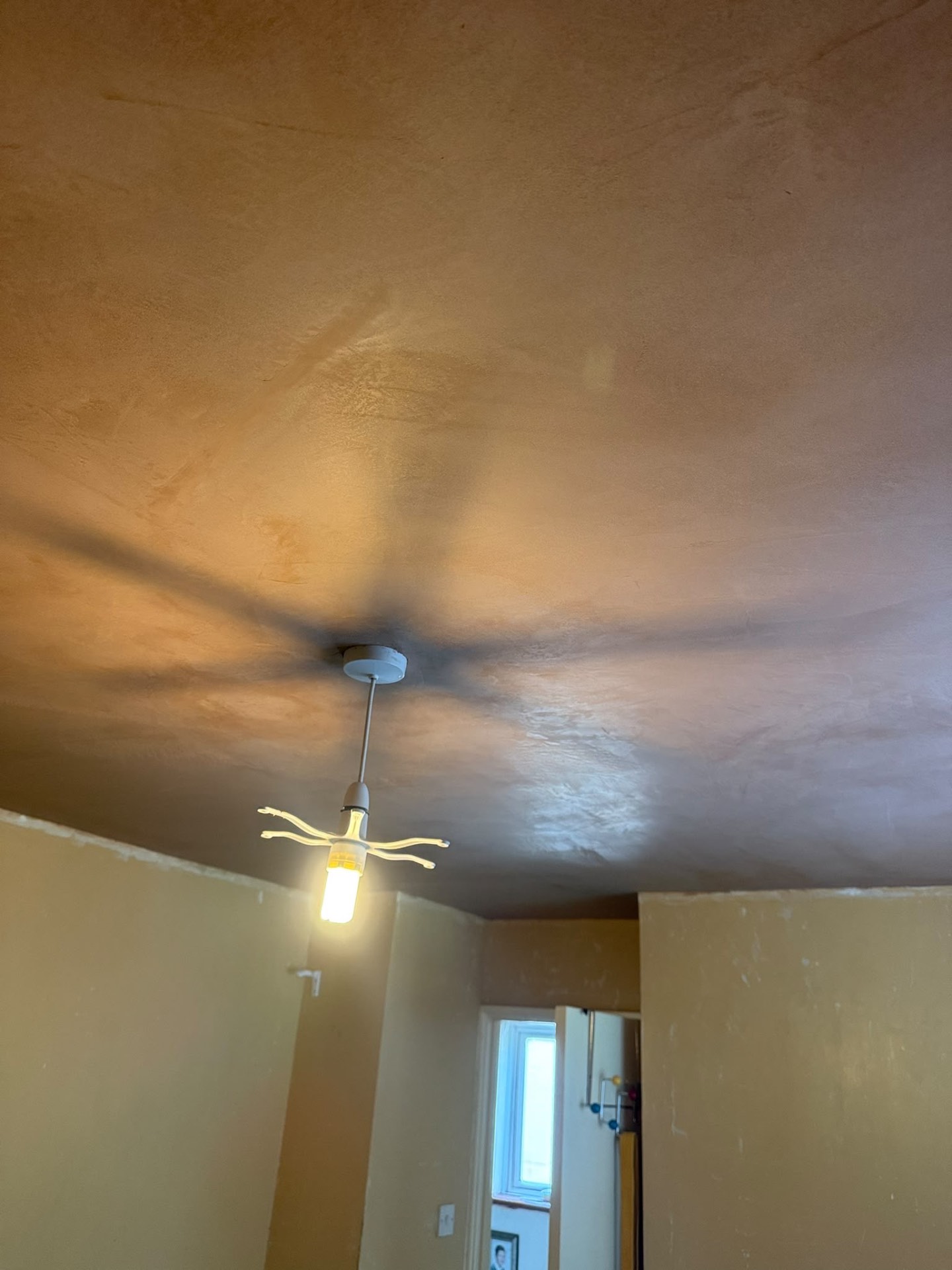 Freshly plastered ceiling around a central light fitting