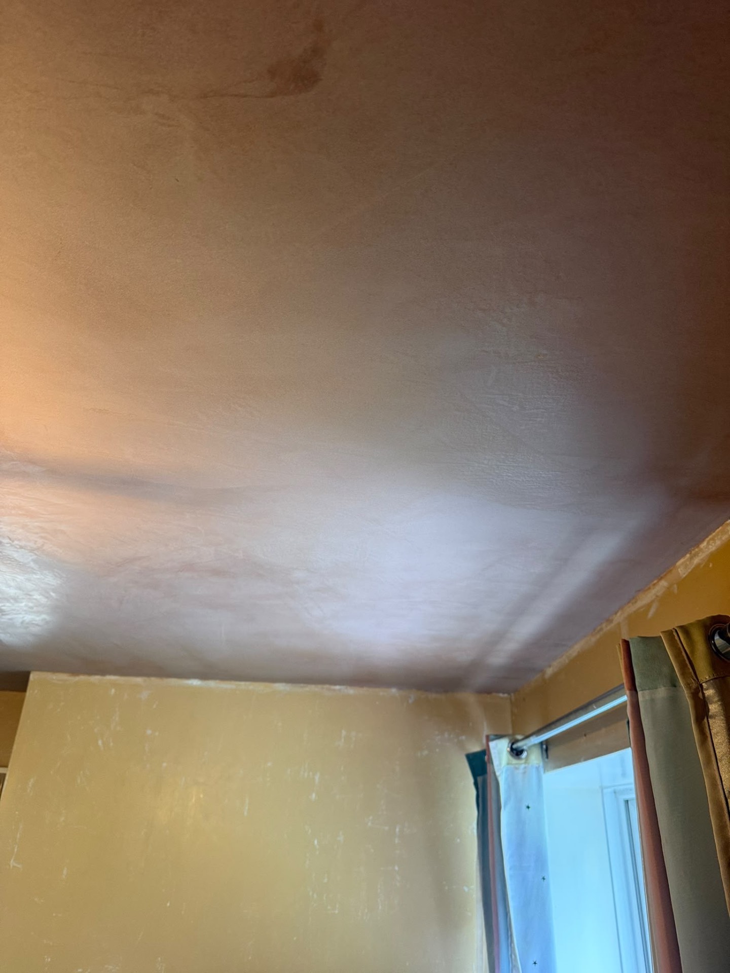 Fresh plaster repair finish across an existing ceiling